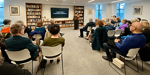 People in room listening to someone speak