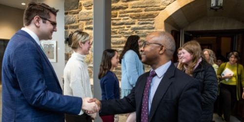 Young boy and older man shaking hands