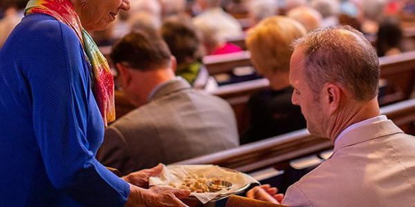 Communion is offered to a worshipper during a service at Bryn Mawr Presbyterian Church